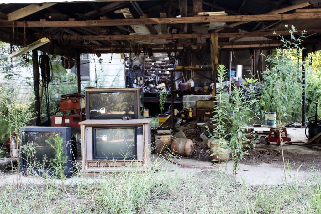 Old tube tvs under a carport 