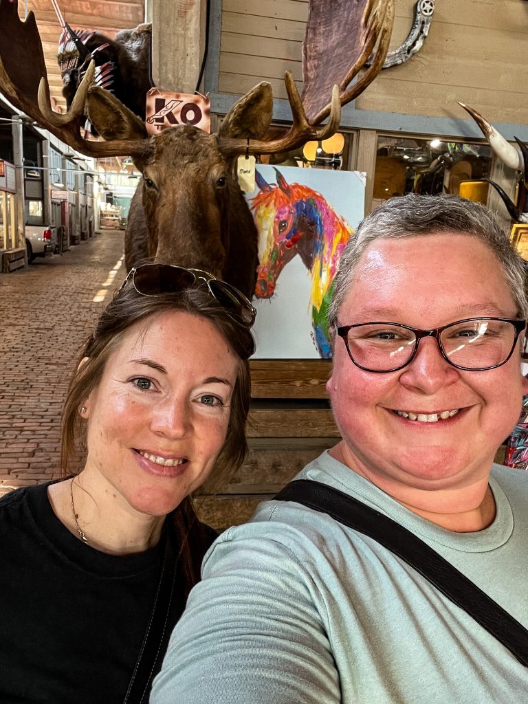 Two women in front of moose